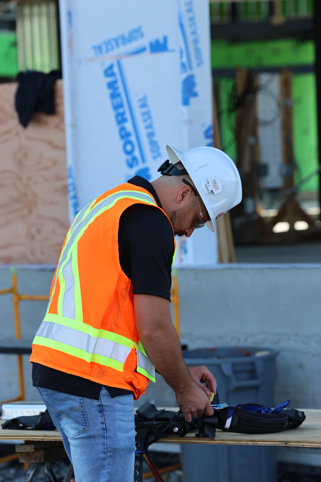 Intervenant SST inspectant un harnais antichute sur un chantier