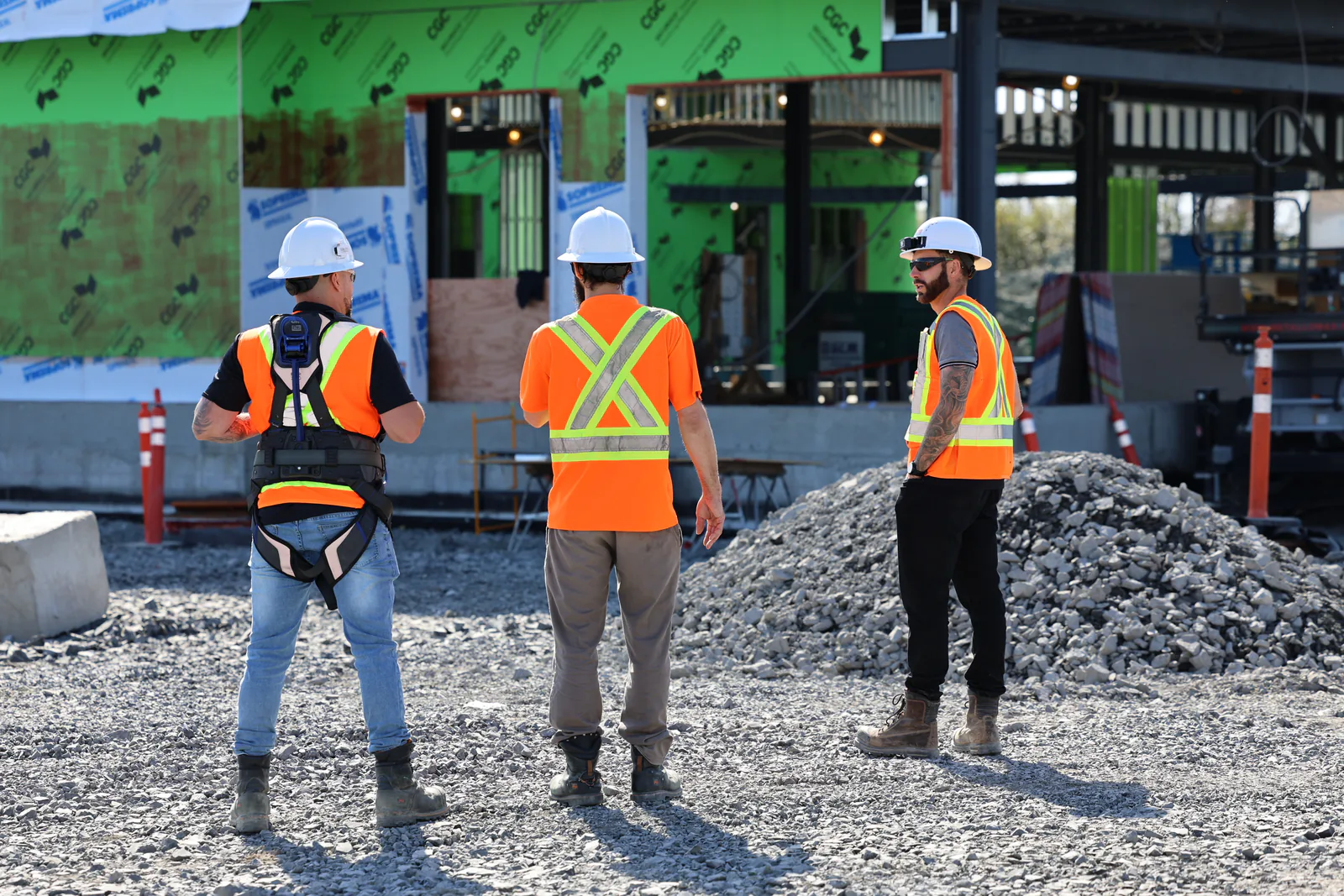 Équipe SST discutant devant un bâtiment en construction