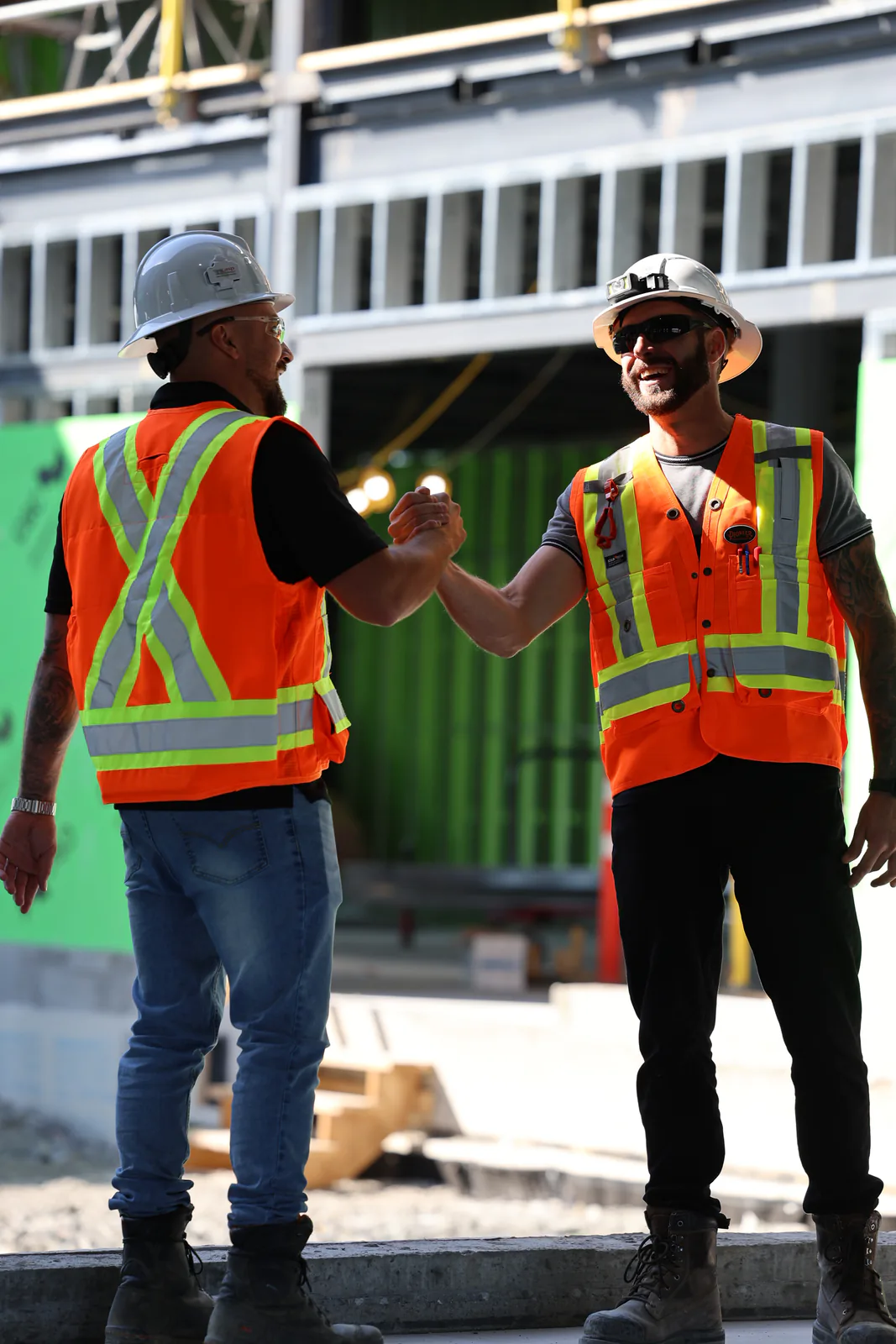 Deux intervenants SST se saluant sur un chantier de construction