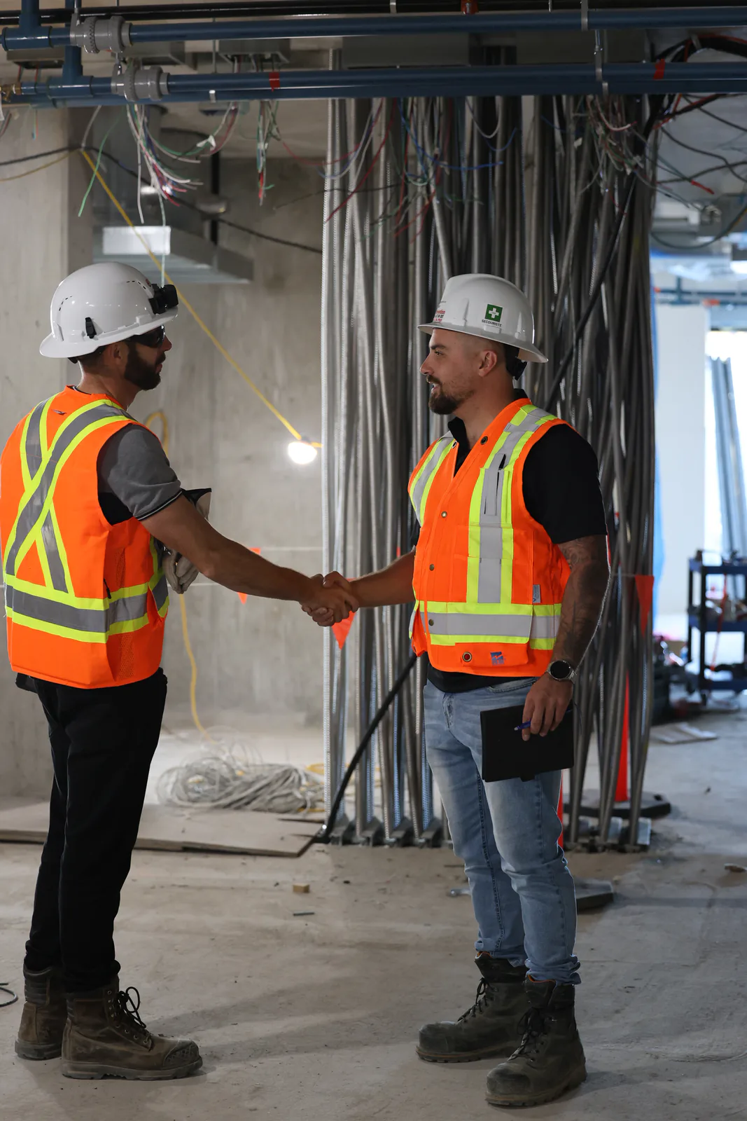 Conseiller SST serrant la main d’un intervenant dans un bâtiment en construction