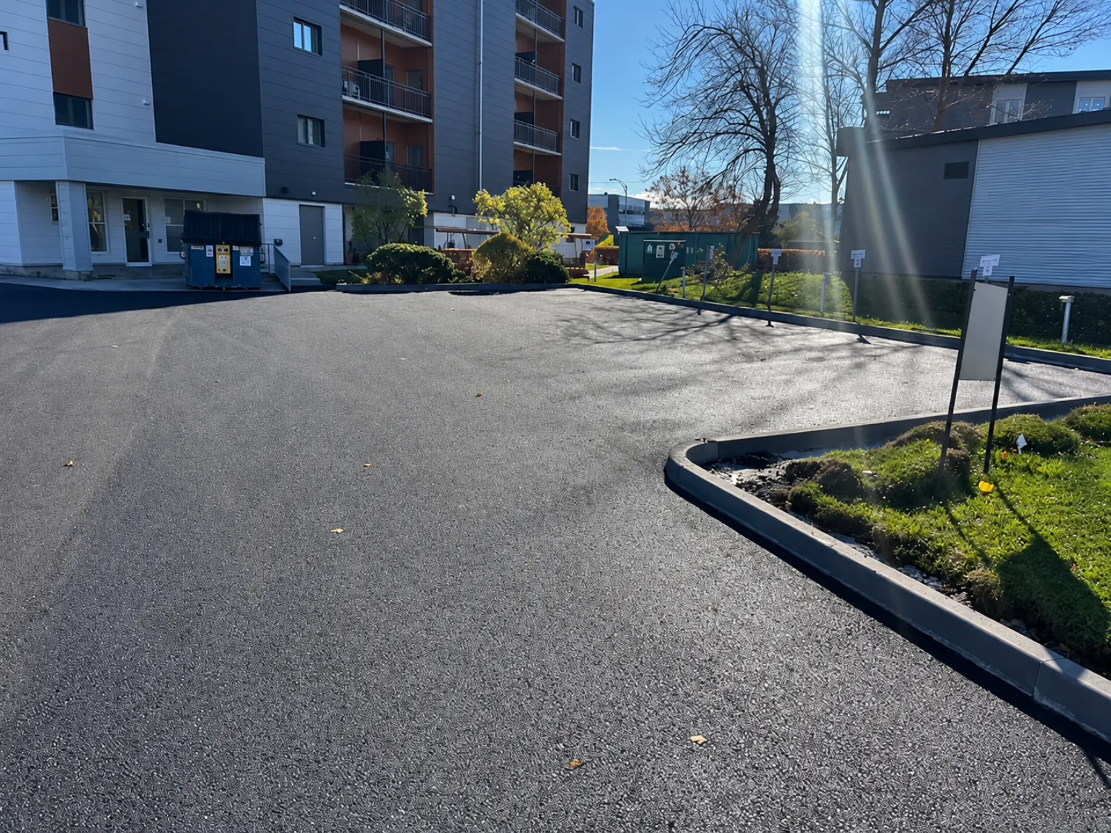 Stationnement asphalté avec bordures de béton neuves